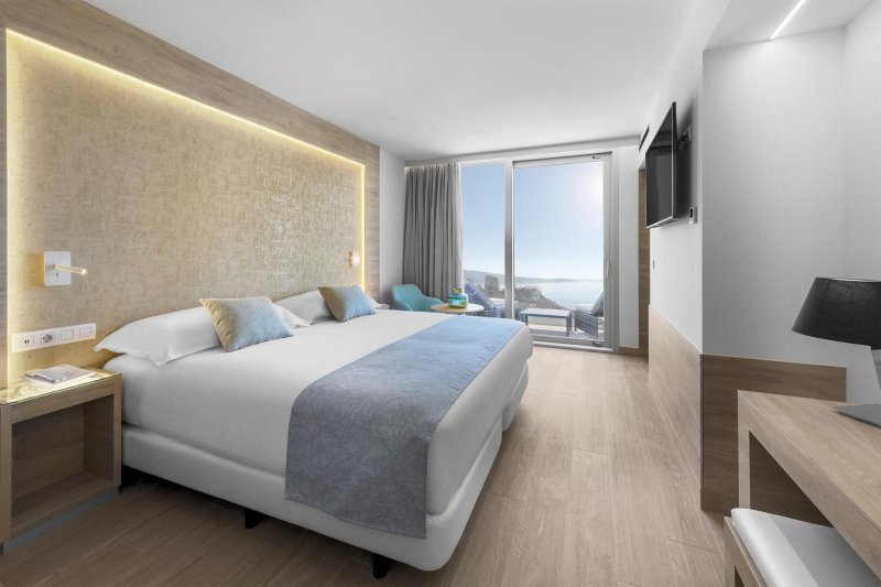 Zeus szoba kétszemélyes ággyal, oldalról tengerre néző kilátással